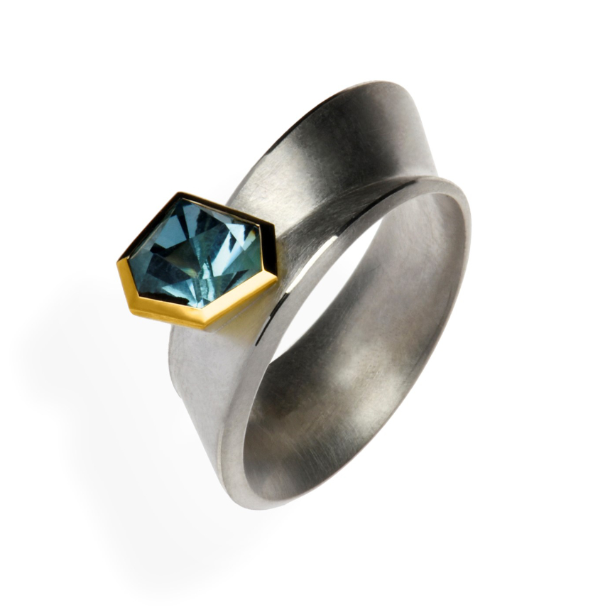 "Stonebow III" ist ein Designerring aus Silber und Gelbgold, verziert mit einem Edeltopas. Gefertigt wurde er in der Goldschmiede Galeriehaus Grosche in Castrop-Rauxel, Nähe Oberhausen.